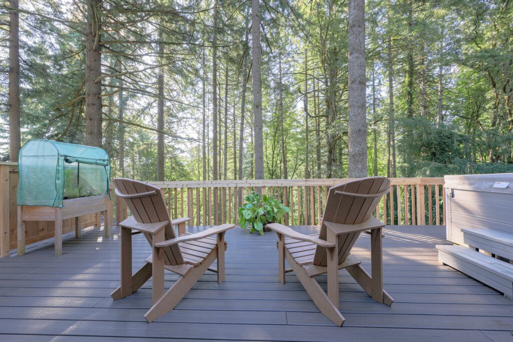 Outdoor wooden deck with Adirondack chairs overlooking a lush evergreen forest in Oregon