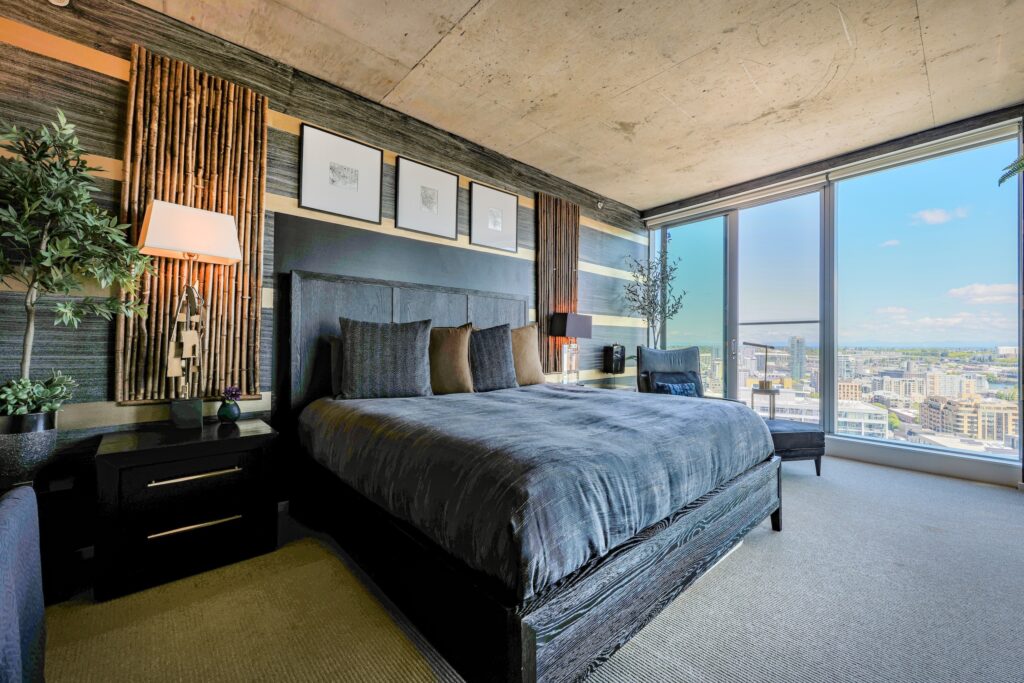 Luxury penthouse bedroom with concrete ceiling, bamboo accents, and panoramic city skyline views