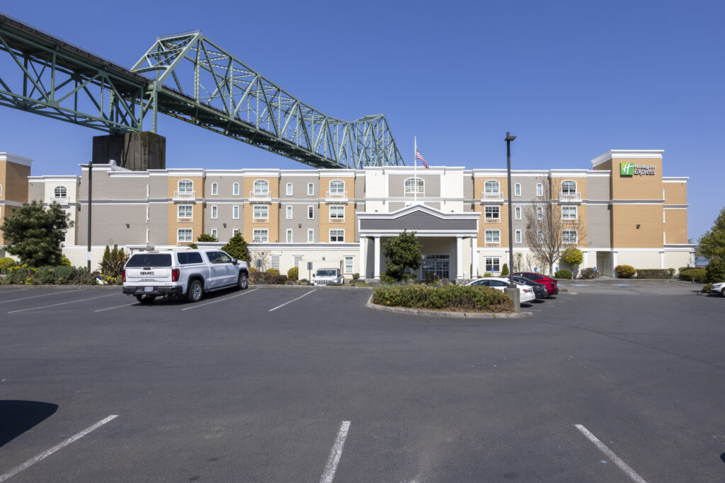 Exterior commercial photography of Holiday Inn Express hotel building with Astoria-Megler Bridge in the background