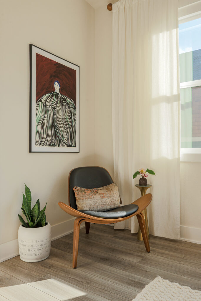 Close-up lifestyle shot of a boutique rental interior with a designer chair and natural light